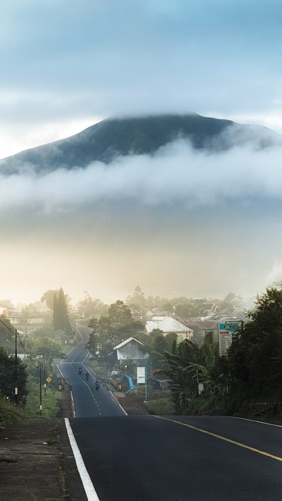 Road leads towards a foggy mountain.